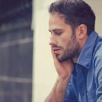 a man holds his cheek and wonders what is meth mouth and what are the effects of meth mouth