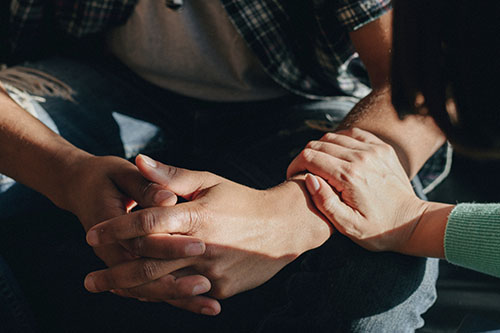 a woman comforts a man as they consider a dual diagnosis treatment program in tampa